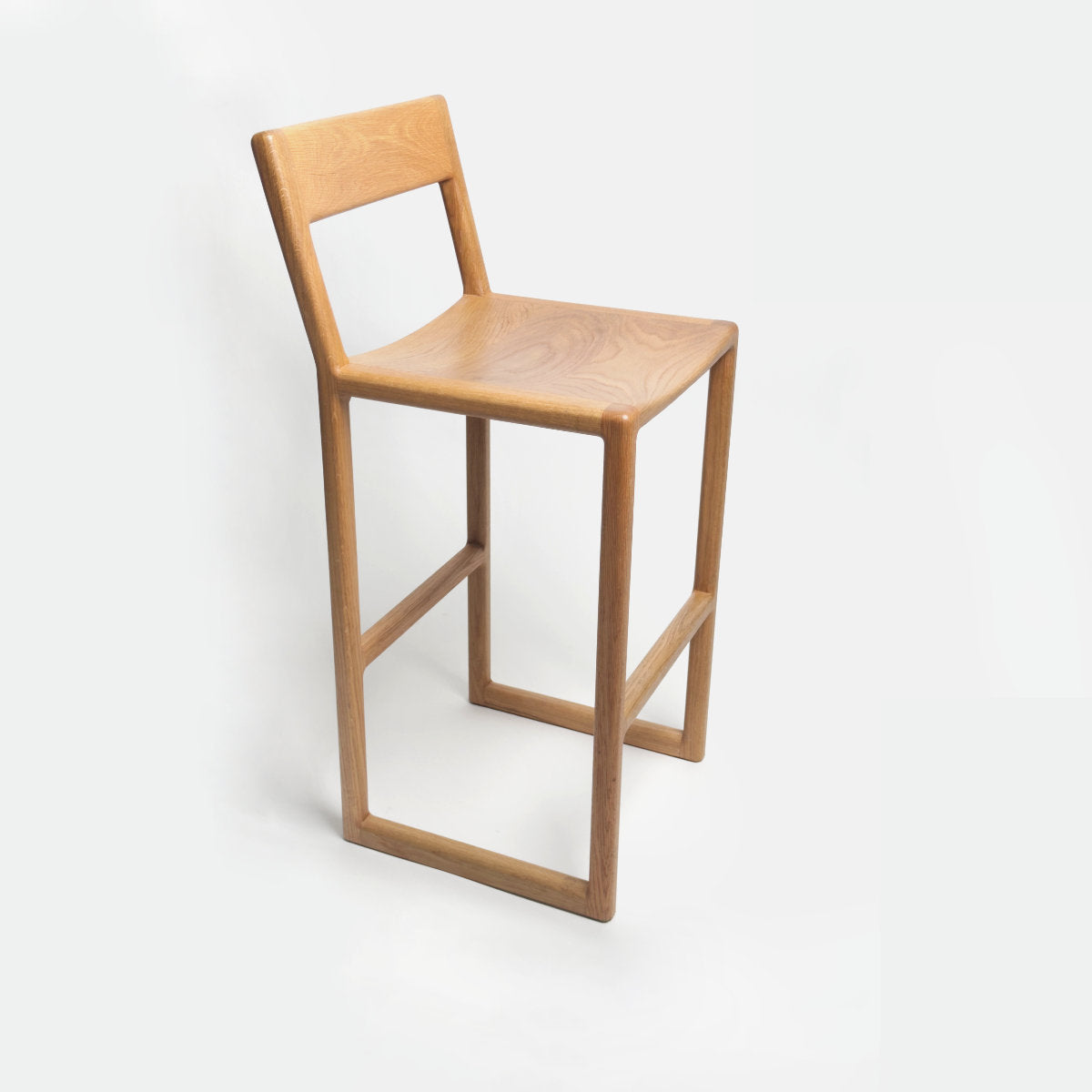 Sturdy oak bar stool with a scooped seat and a back restd 